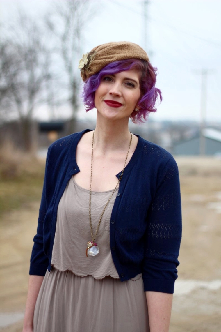 Outfit: Beige dress, navy cardigan, tan floppy hat attached to a headband, dark lipstick, lavender hair