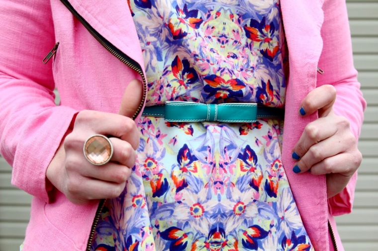 Outfit details: Abstract printed peplum sleeveless top, pink moto jacket, teal belt, champagne colored statement ring